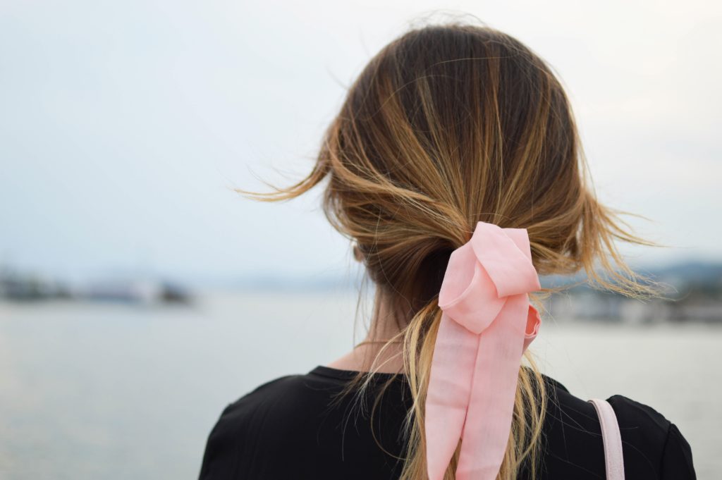 Kobieta z rózową wstążką we włosach, różowa wstążka symbolizuje walkę z rakiem szyjki macicy